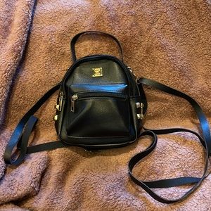 Tiny backpack with subtle gold accents